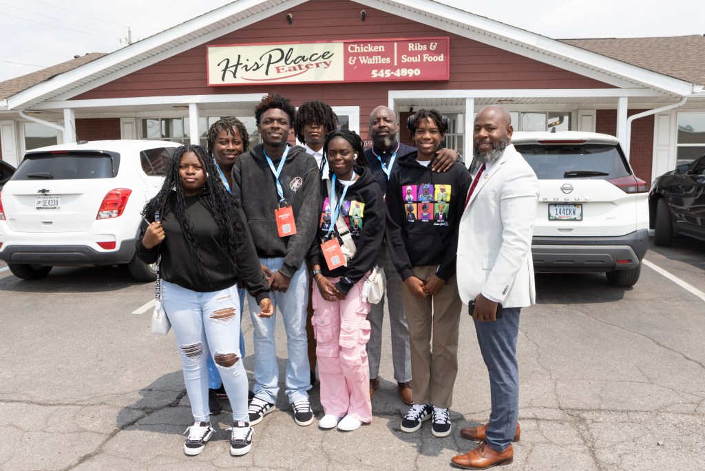 Group of residents and staff standing together outdoors in front of a local business