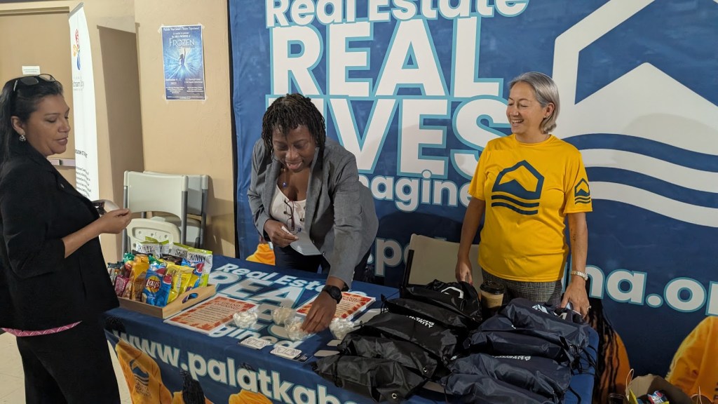 Palatka Housing Authority staff members standing behind an information table indoors