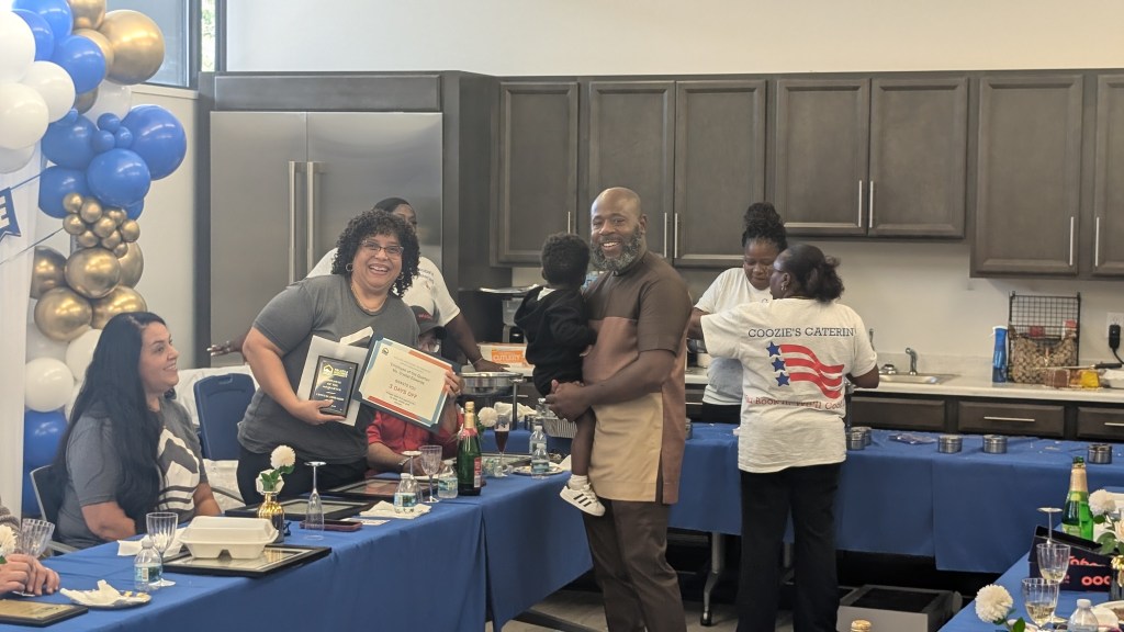 Residents and staff serving food together at a Palatka Housing Authority community event