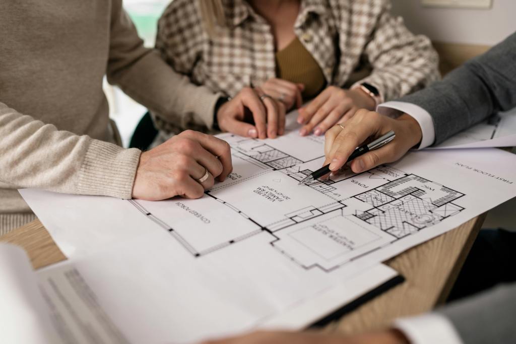 People reviewing architectural plans on a table