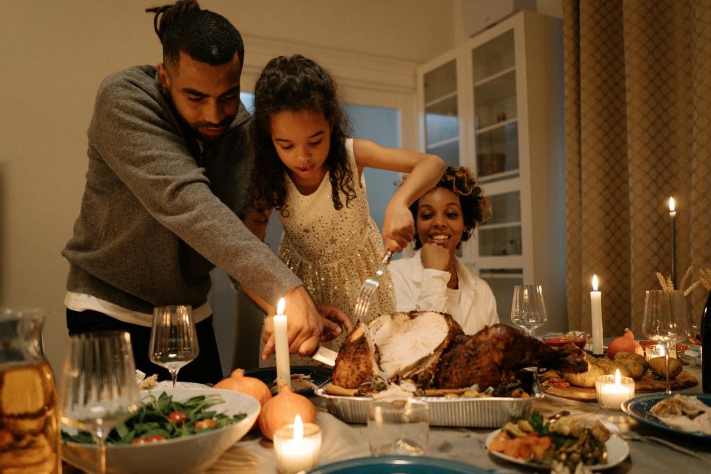 Group of people gathered around a table preparing a meal together indoors