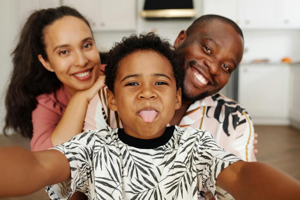 Smiling adults and a child posing together indoors